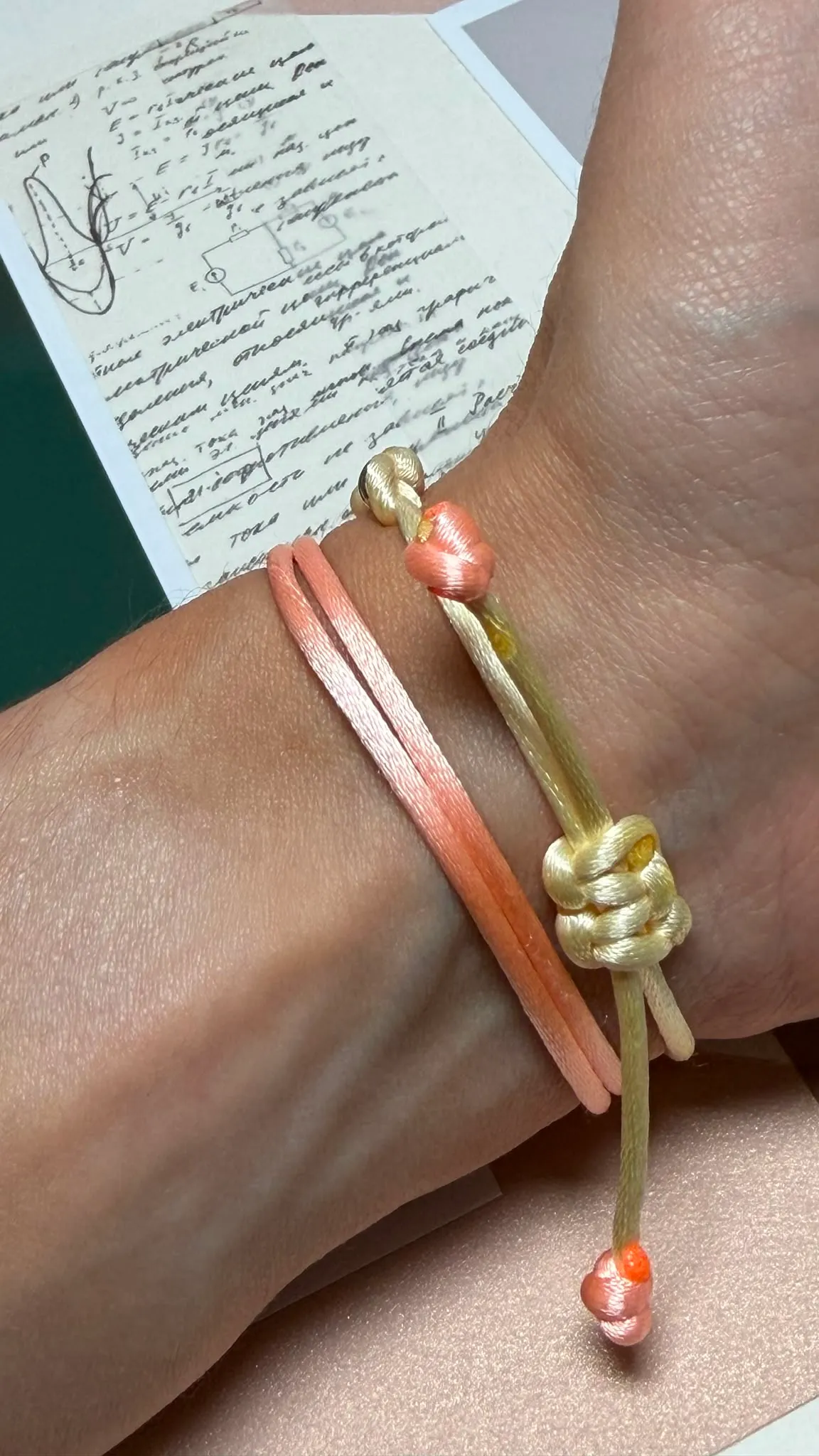 Les nœuds des cordons au poignet, bracelets « Le grain » portés.